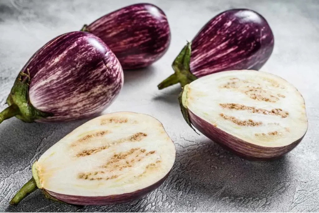 Baba Ganoush served in a bowl with olive oil and herbs, surrounded by pita bread slices