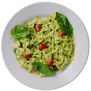 Bow Tie pesto salad with cherry tomatoes on a white round plate