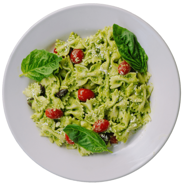 Bow Tie pesto salad with cherry tomatoes on a white round plate