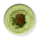 Spinach Hummus a green dip on a white plate