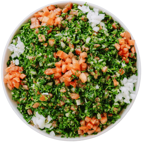 Tabouli Salad a chopped parsley mixed with diced tomatoes and onions in a white bowl