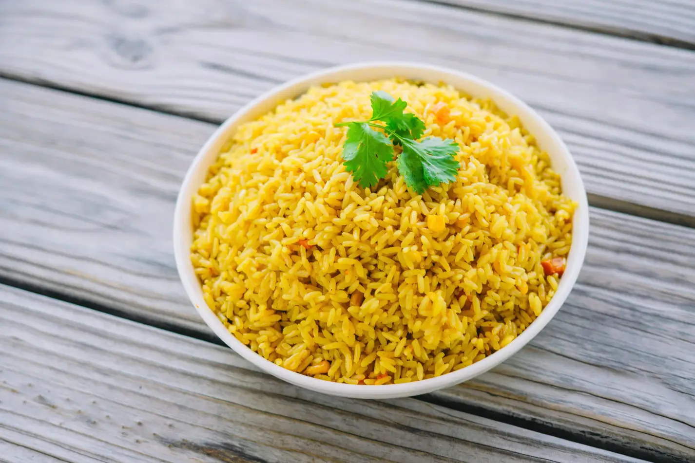 a bowl of Saffron rice on a wood surface. Mediterranean food Houston