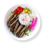 Lamb Gyro -cooked lamb gyro strips roasted on a vertical rotisserie, plated (no wrap) with rice and salad at Aladdin Mediterranean cuisine